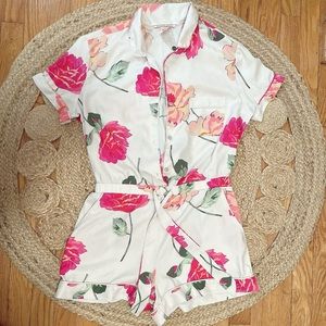 Satin floral printed short Romper with pearlized button closure and waist tie.